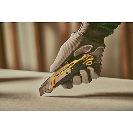 Stanley fatmax snap off knife with slide lock 18 millimeter being used to cut a sheet.