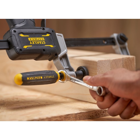 STANLEY® FATMAX® Hybrid Trigger Clamp, 300mm close up of hand turning a wrench attached to bolster to tighten hold