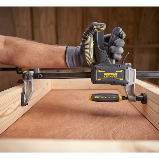 STANLEY® FATMAX® Hybrid Trigger Clamp, 300mm close up of clamp being used as a spreader between upright sides of wooden frame