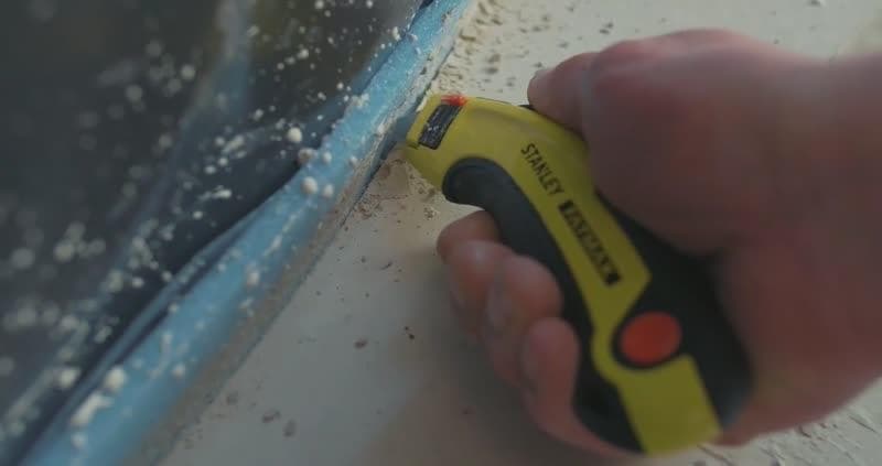 Des gros plans montrent une personne utilisant un cutter Stanley FATMAX (modèle 11-700) pour couper et retirer de la mousse bleue et du plastique sur une surface, mettant en avant la lame, le bouton de sécurité et le processus de coupe, avec le logo Stanley FATMAX présenté.