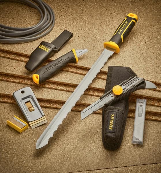 STANLEY 0-28-500 ensemble d’outils à main avec couteaux de coupe, râpe, lames utilitaires et poignées noir-jaune sur surface beige.